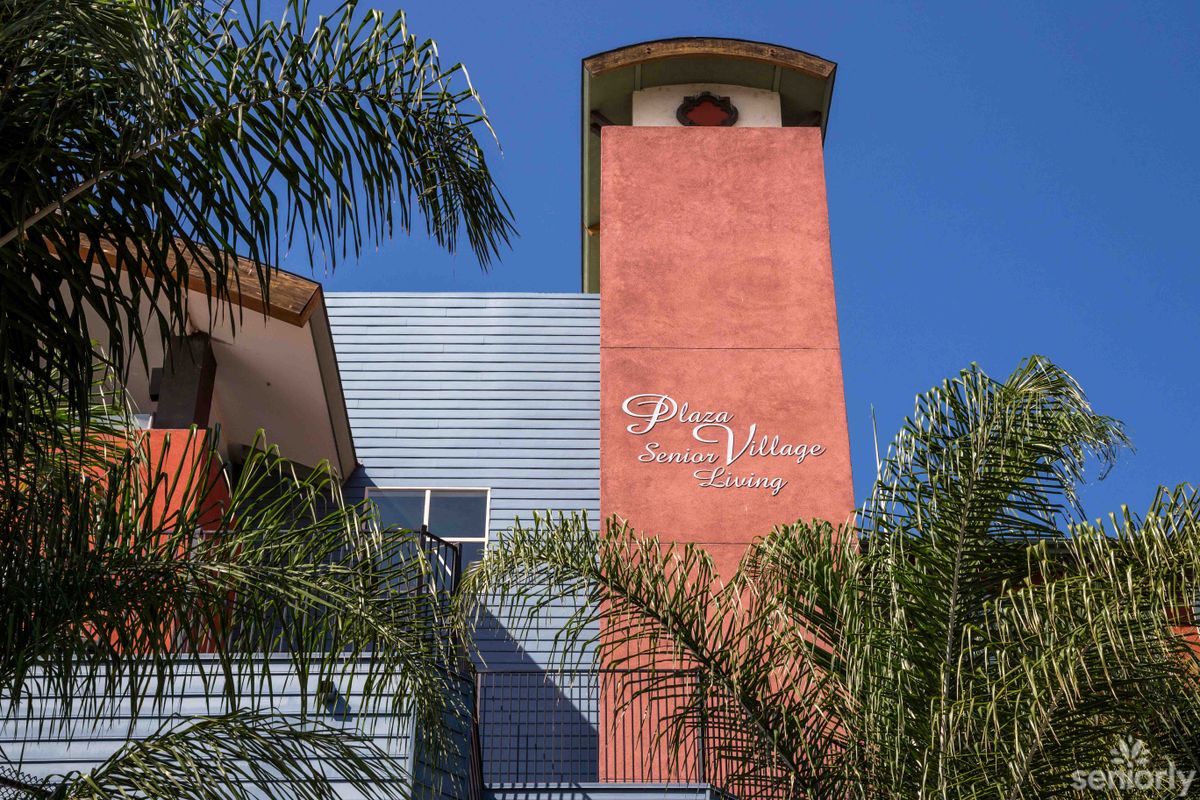 A colorful tower with palm trees in the foreground under a clear blue sky.