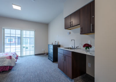 A modern kitchenette area in a minimalist apartment setting.