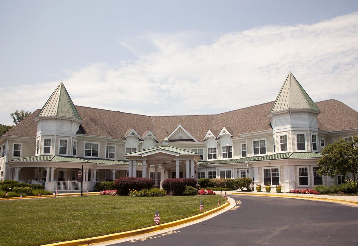 A large and elegant residential building with a distinctive architecture, featuring multiple gables and a circular driveway.