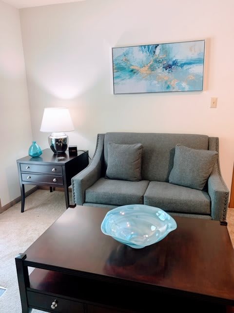 A cozy living room with a gray sofa, decorative pillows, and a stylish coffee table centerpiece.