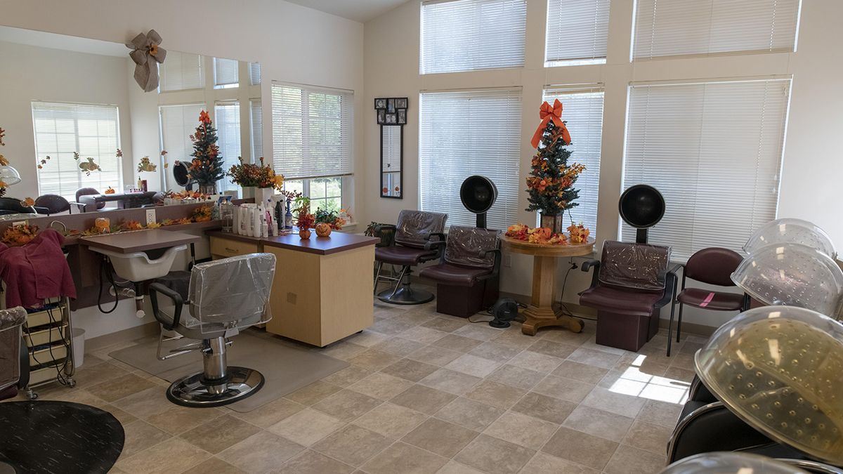 A well-lit salon interior with chairs, mirrors, and festive decorations.