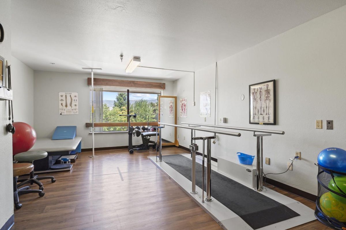 A physical therapy room equipped with parallel bars for rehabilitation exercises.