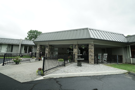 A welcoming entrance of a modern facility with a stone facade and a well-maintained landscape.
