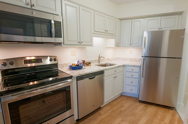 A modern kitchen with stainless steel appliances and white cabinets.