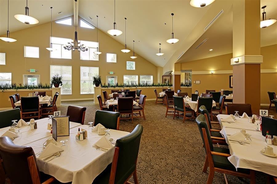 A spacious dining area with elegantly set tables and large windows.
