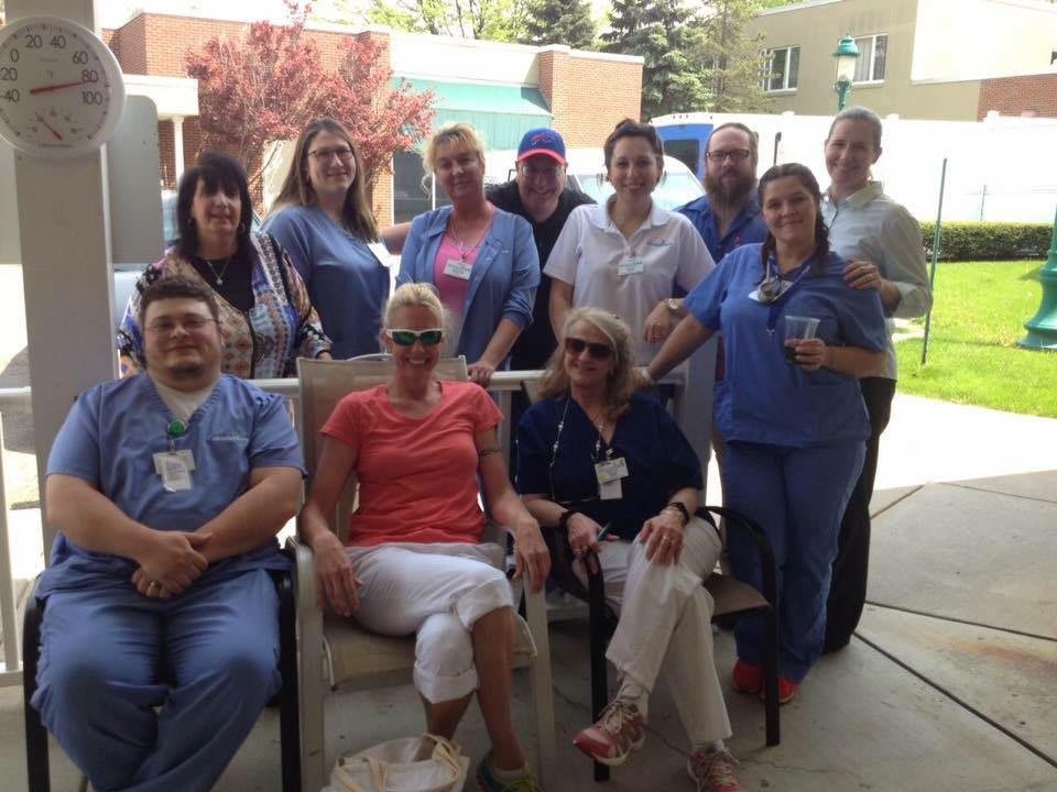 A group of people gathered outdoors, some in casual attire, posing together.