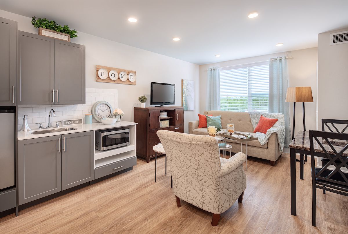 A modern and cozy apartment living area with a kitchenette and comfortable seating.