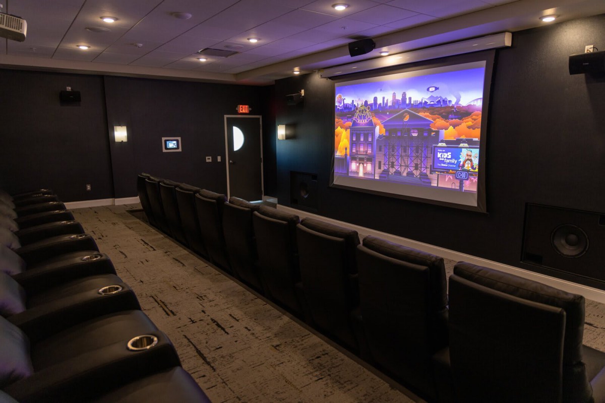 A cozy home theater with comfortable seating and a large projector screen.