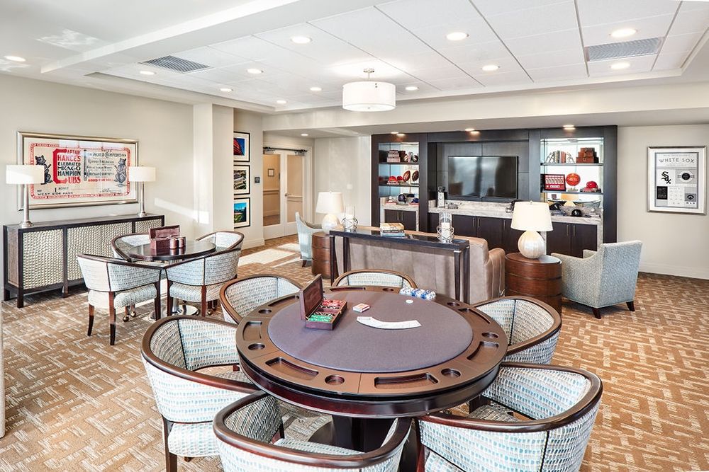 A luxurious lounge with a poker table and comfortable seating.