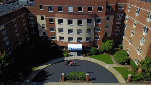 An aerial view of a modern residential building with landscaped surroundings.