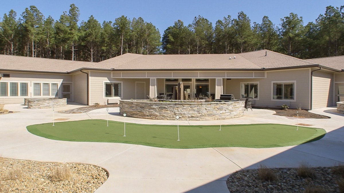 A modern house with a spacious backyard patio and surrounding greenery.