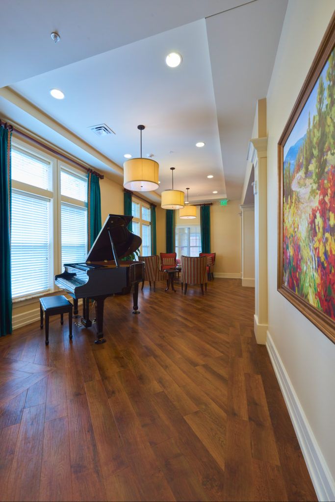 A spacious living room with a grand piano and elegant furnishings.