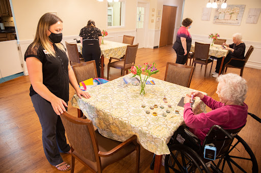 Caregivers assisting seniors in an activity at an assisted living facility.