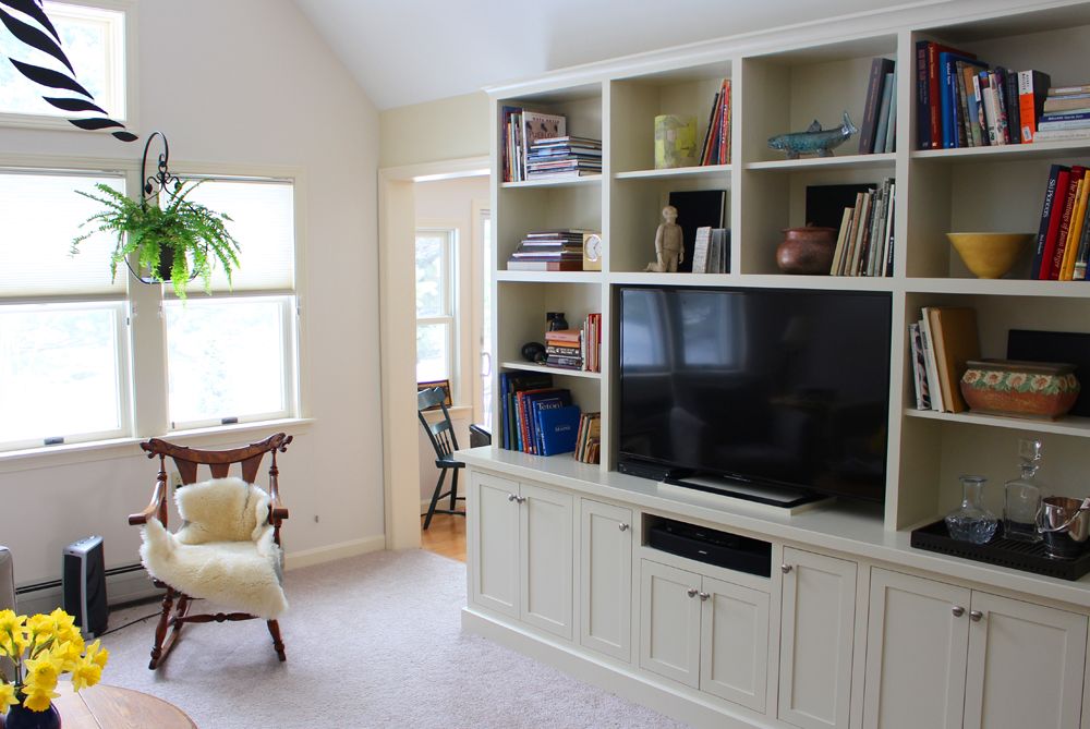 A cozy living room with a large bookshelf and television.