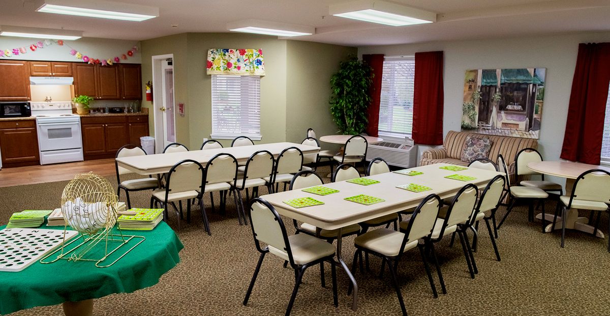 An empty classroom or meeting room set up with tables and chairs, ready for an event or class.