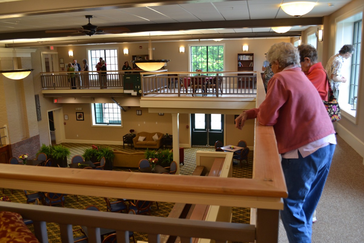 A spacious hotel interior with multiple levels and people observing from the balcony.