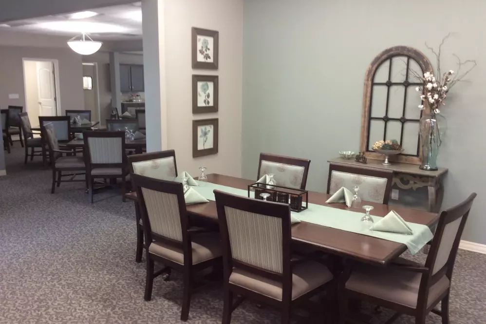 A neatly arranged dining room with a table and chairs, featuring elegant decor.