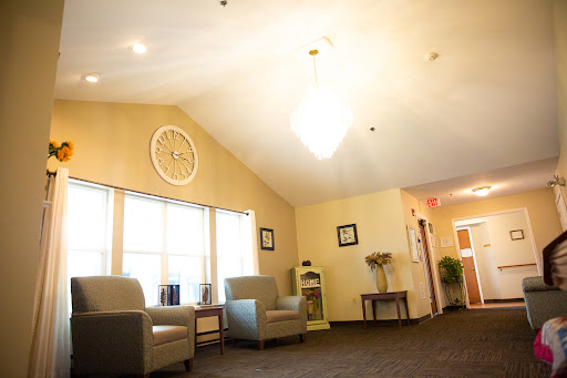 A cozy waiting area featuring comfortable chairs, a wall clock, and ample natural light.