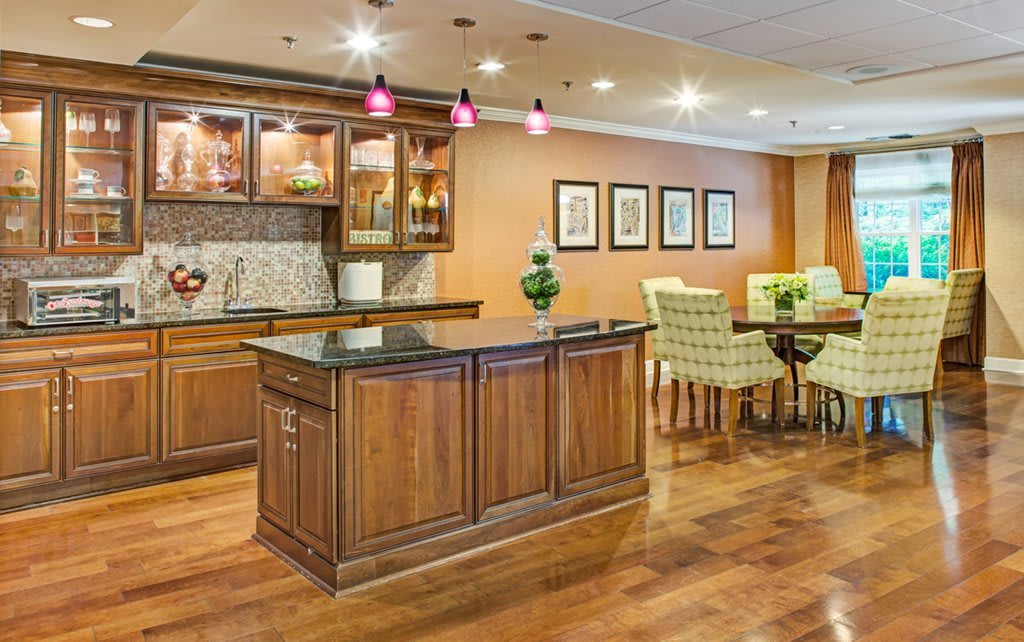 A modern kitchen and dining area featuring wooden cabinetry, an island counter, and elegant interior design.
