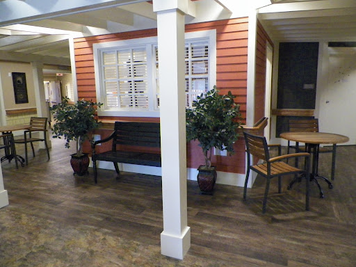 A cozy waiting area featuring a bench, a small table, and potted plants.