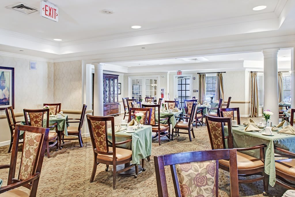 A spacious dining room with elegantly set tables and chairs.
