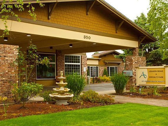 A well-maintained building entrance with a decorative fountain and lush landscaping.
