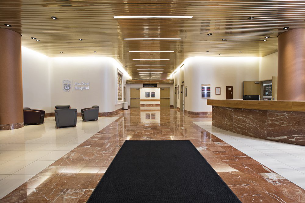 Modern office lobby with a reception desk and seating area.