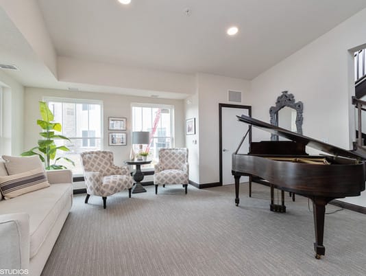 A stylish living room featuring a grand piano and cozy seating area.