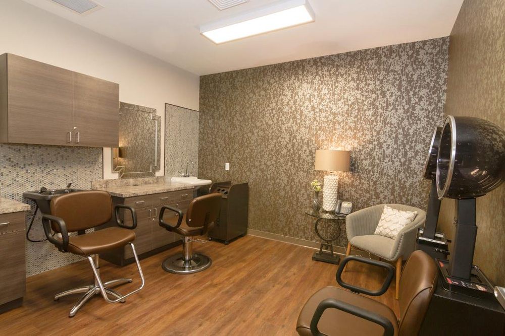 A modern beauty salon with stylish chairs and a decorative wall.