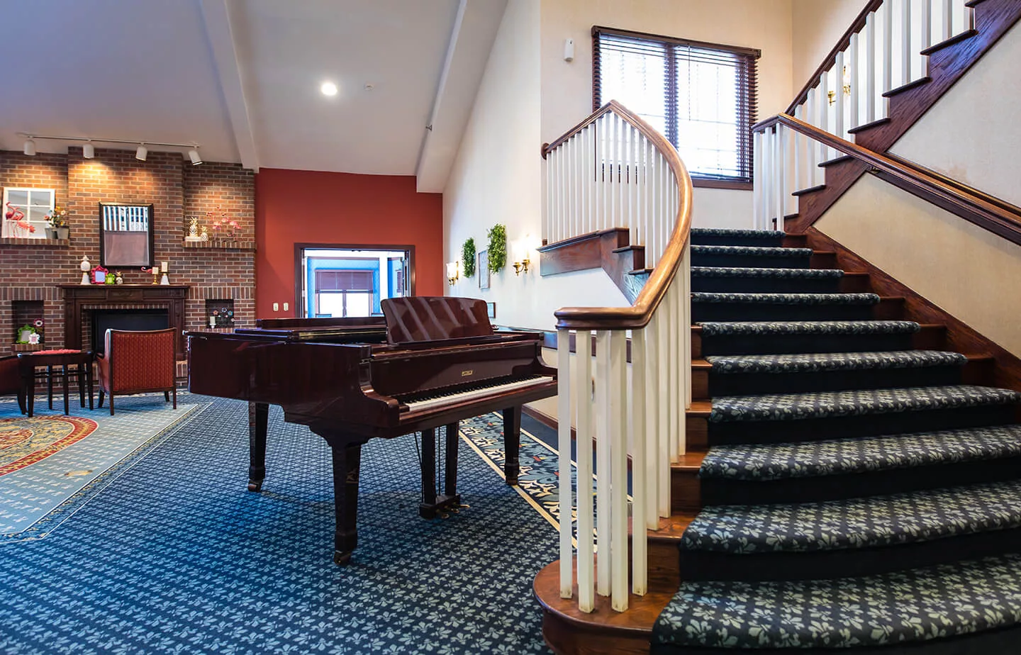 A well-decorated living space featuring a grand piano and a carpeted staircase.
