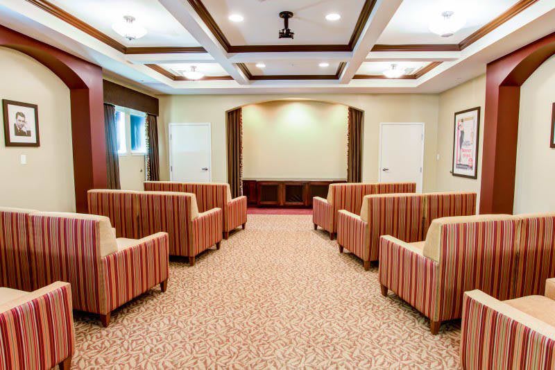 A well-lit conference room with comfortable seating arranged in rows.