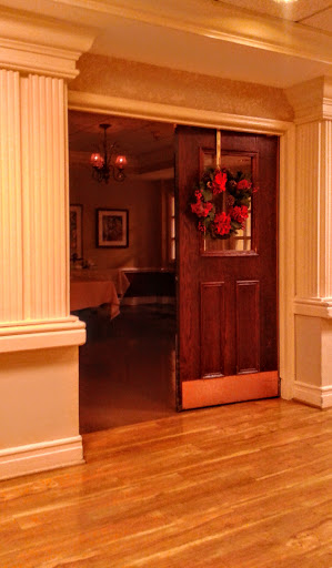 A beautifully decorated entryway featuring a wooden door adorned with a festive wreath.