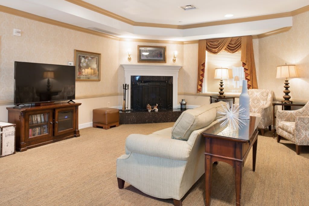 A cozy living room featuring a fireplace, sofa, and television.