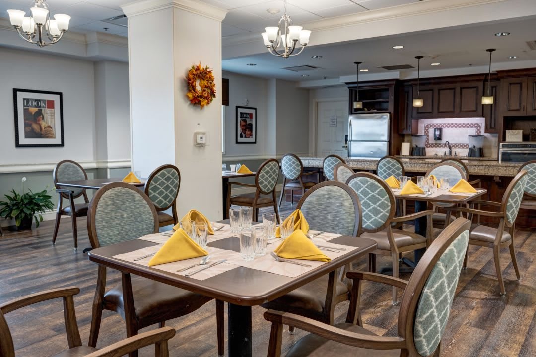 An elegant dining room with neatly set tables and chairs, featuring a warm and inviting atmosphere.