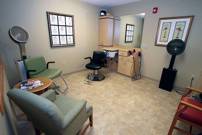 A cozy waiting area in a hair salon with seating and a mirror.