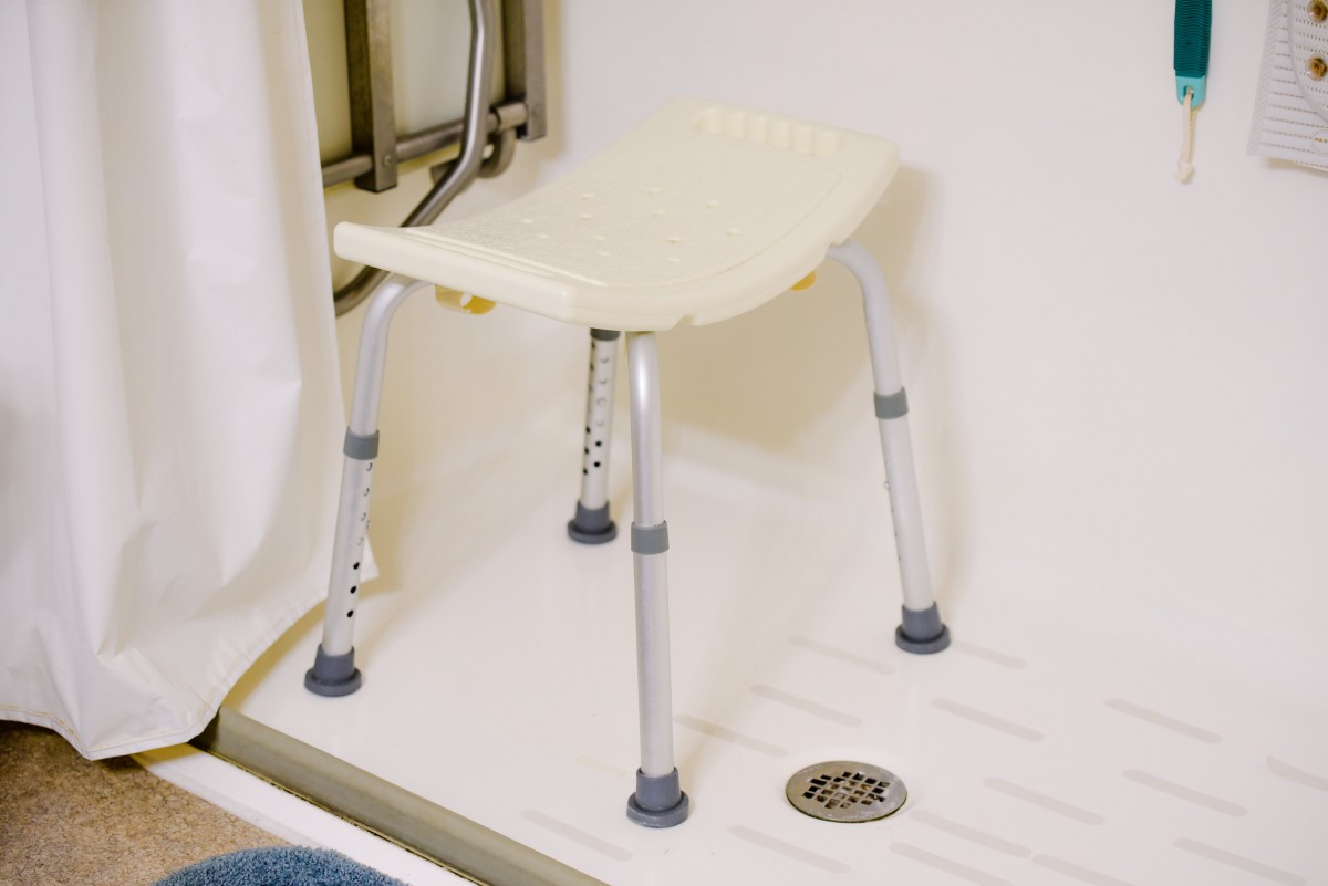 A shower chair placed inside a bathroom shower for accessibility.
