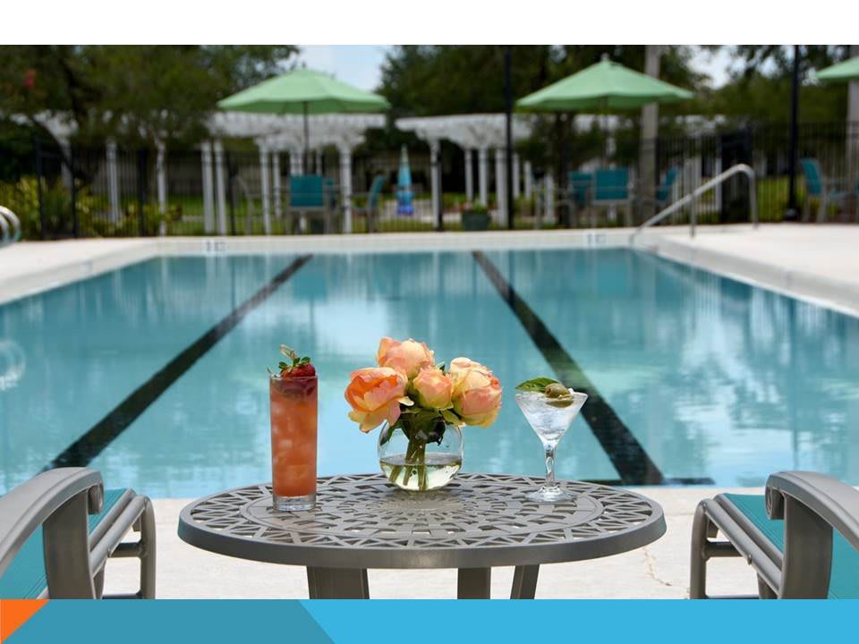 A serene poolside setting with drinks and flowers, perfect for a relaxing summer day.