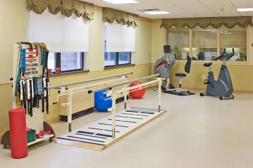 A well-equipped therapy room designed for physical rehabilitation with walking bars and exercise equipment.