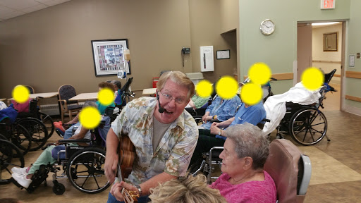 A lively performance in a care facility, where a musician engages with residents through music.
