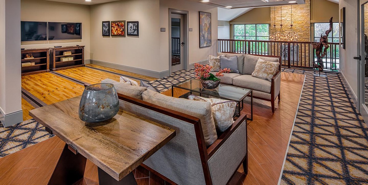 A modern living room with comfortable seating, art on the walls, and wooden floors.