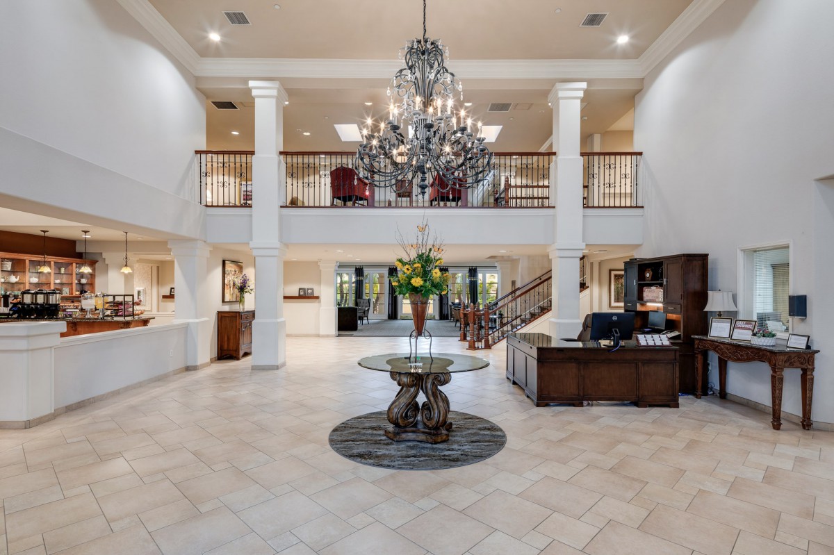 Luxurious hotel lobby with a grand chandelier and elegant reception area.