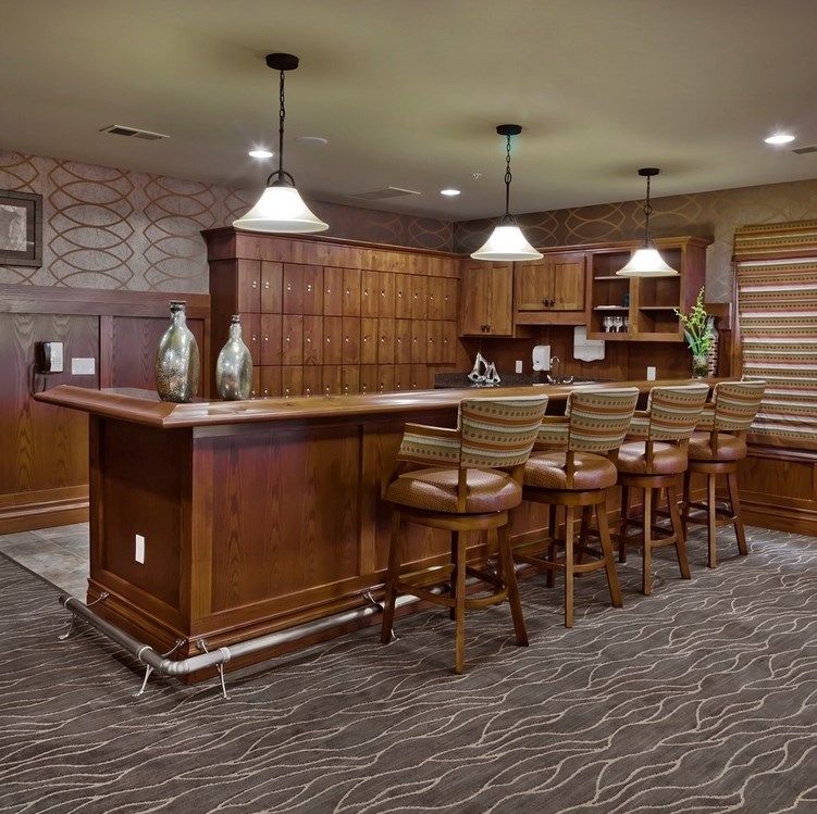 A cozy home bar featuring wooden furniture and modern lighting.