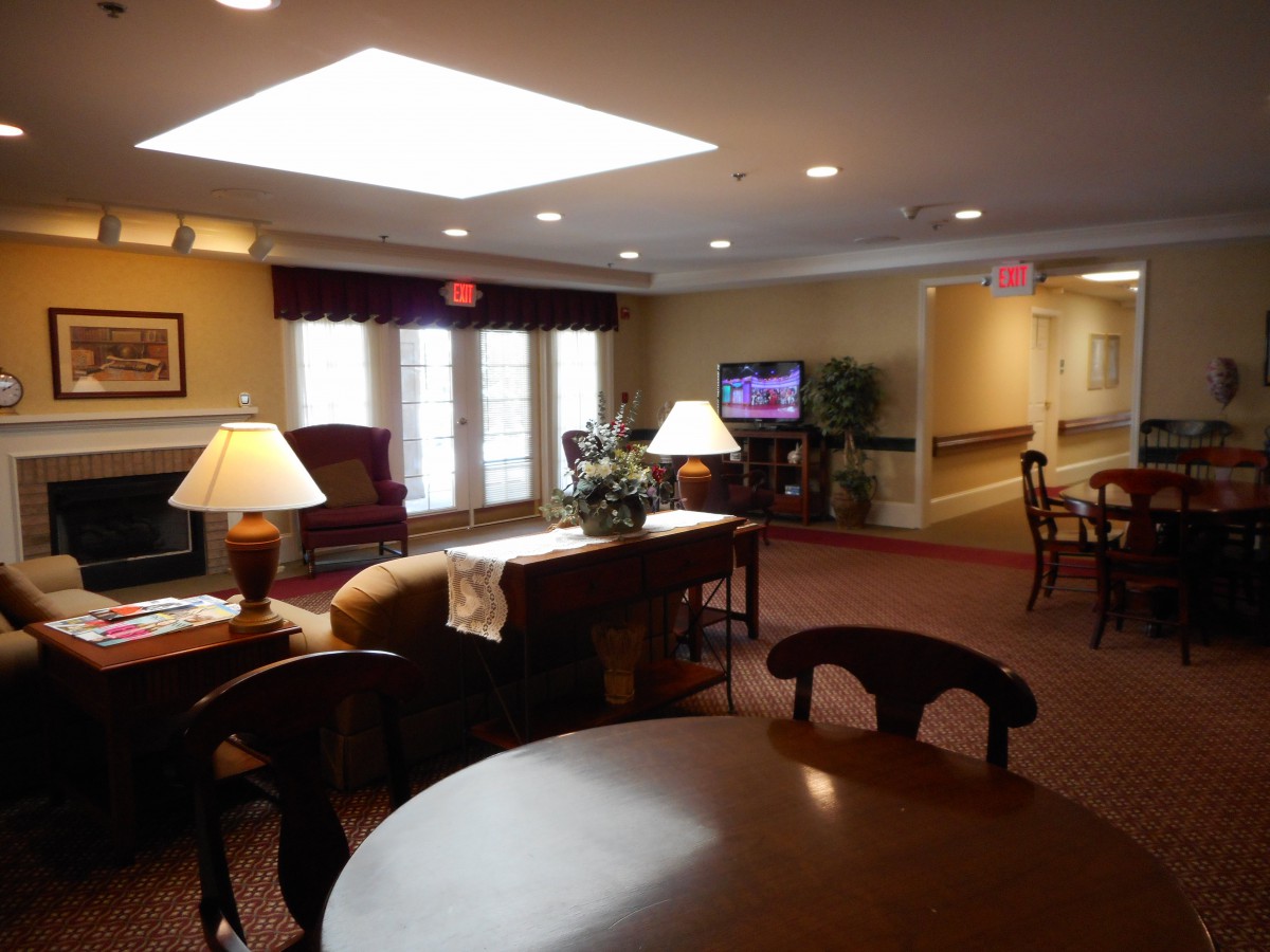 A cozy lounge area featuring comfortable seating, a television, and ambient lighting.