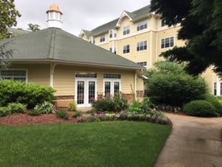 A charming building with well-maintained gardens and a walkway.