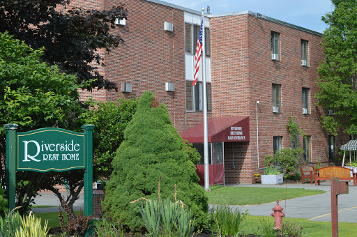 A residential building featuring greenery and an American flag at its entrance.