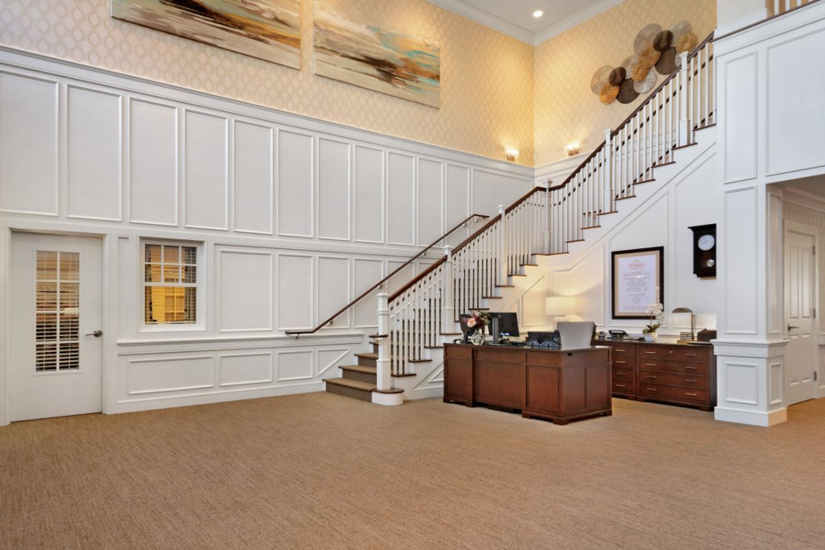 Spacious office lobby with a grand staircase and reception desk.