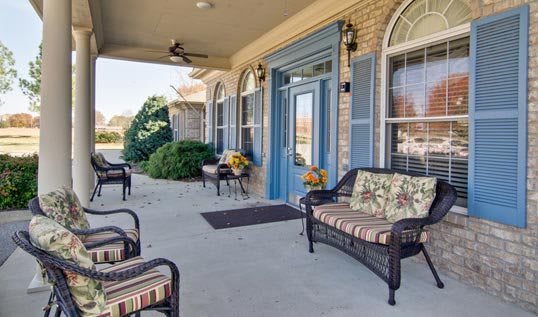 A cozy outdoor patio area with wicker furniture and floral decor.