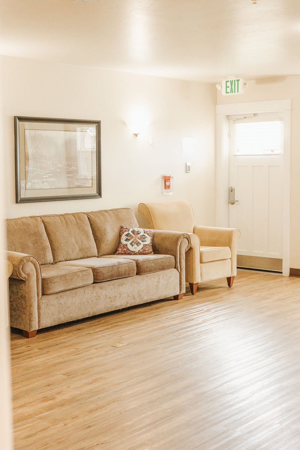 A cozy living room with a sofa and armchair on a wooden floor.
