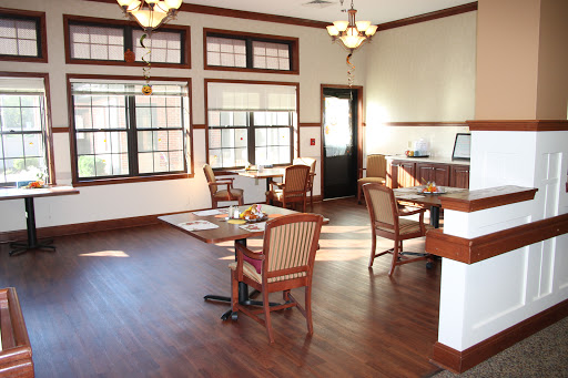 A well-lit dining area featuring wooden flooring and elegant furniture.
