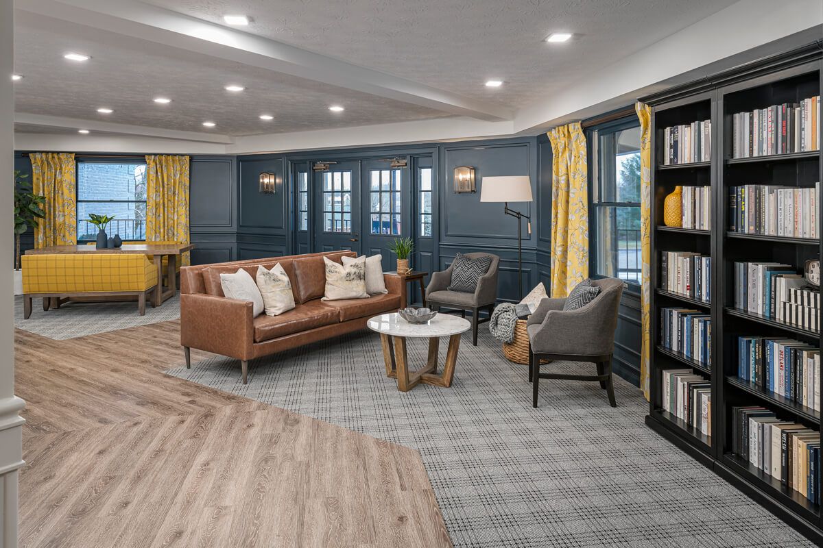 A modern living room with a stylish sofa, armchairs, and a coffee table on patterned carpet.